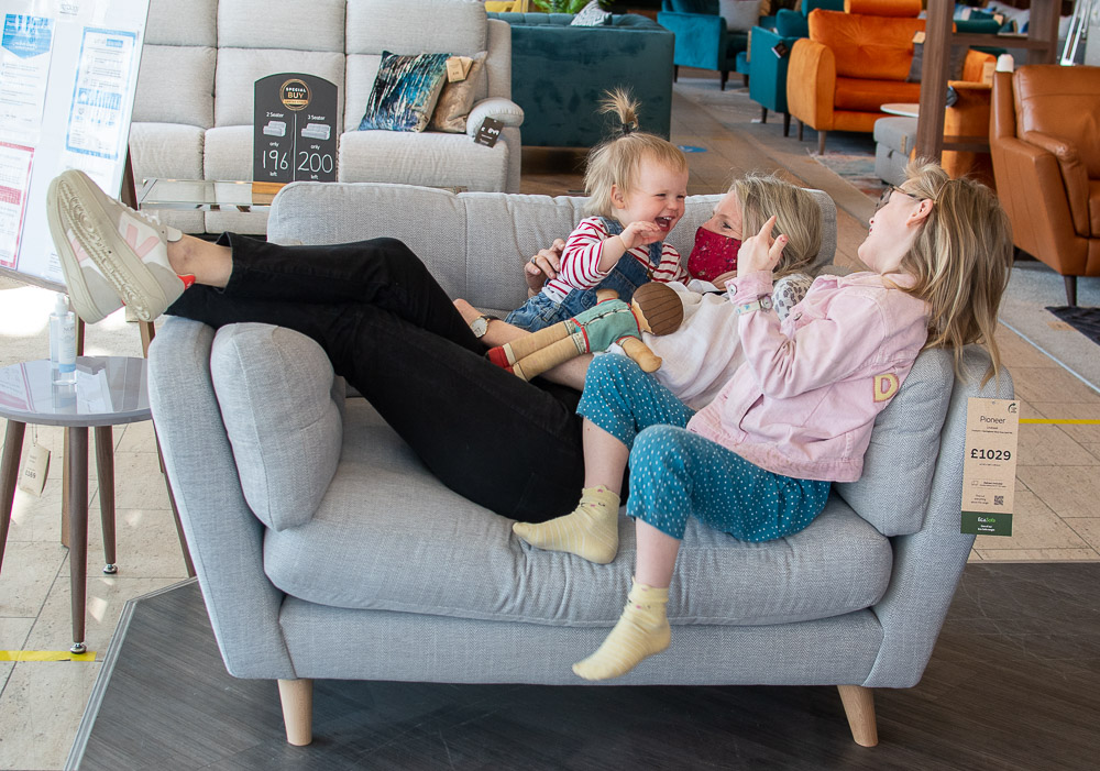 Karen Maurice, sustainable style blogger, and her children lounging around on a Pioneer love seat from Sofaology